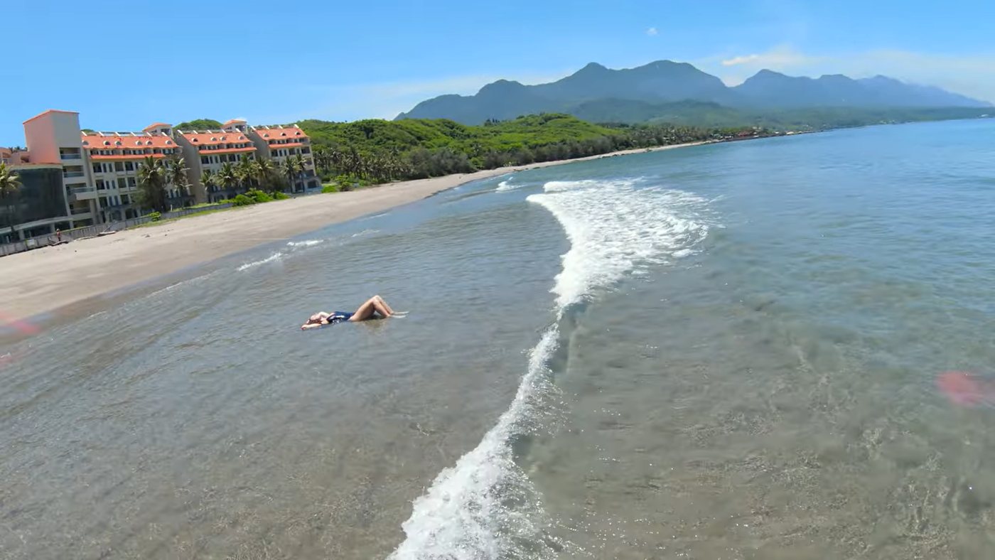 美麗灣浪花、遠山與躺在淺海中的旅人